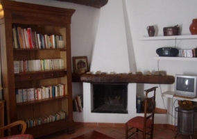 Sala de estar con chimenea y sillones burdeos