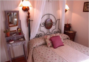 Dormitorio con cama de matrimonio con visel