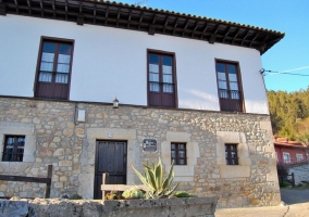 Fachada con muro de piedra y ventanas de madera