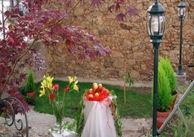 Flores en el jardín con fachada de piedra