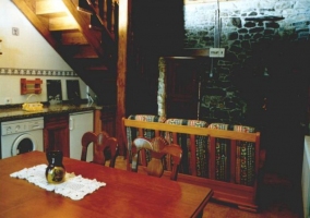 Cocina comedor con paredes de piedra y mesa de madera