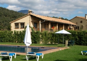 Piscina exterior con tumbonas y zona de hierba