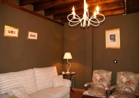 Sofá. sillones y techo de madera con vigas en el salón