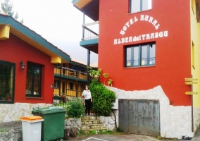 Fachada roja con muro de piedra