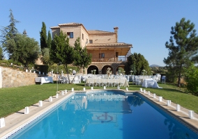 Piscina y fachada con mesas para evento