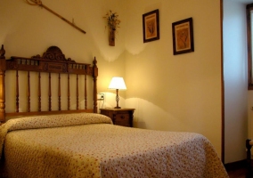 Habitación de matrimonio con cabecero de madera tallada