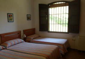 Habitación con cama matrimonial y cabecero largo de madera