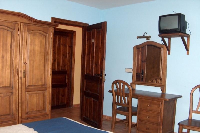 Dormitorio con mobiliario de madera. Color azul