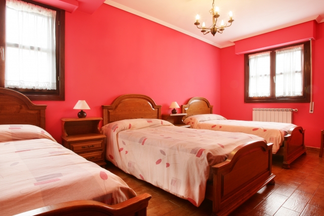 Habitacion rosa con 3 camas