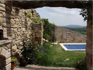 Fachada trasera de piedra con piscina