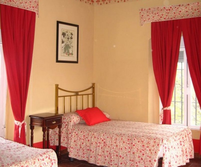 Dormitorio con camas individuales en tonos rojos florales 