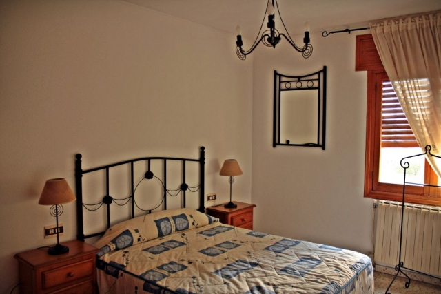 Dormitorio con cama de matrimonio y lamparillas sobre las mesillas