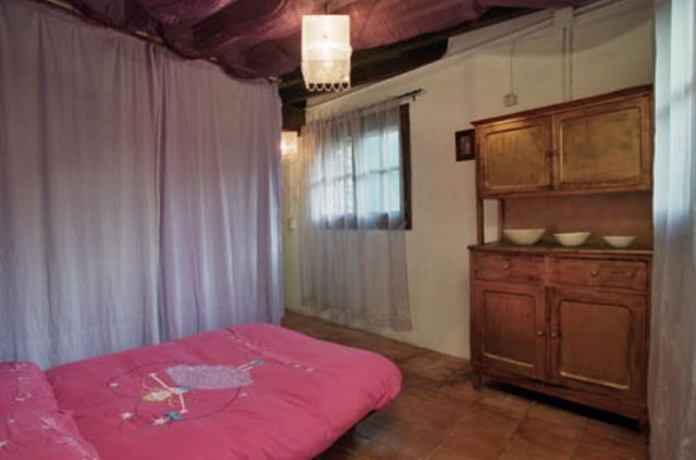 Dormitorio con cama rosa y mueble de madera