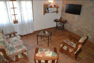 Sala de estar con sillones tapizados y televisor de plasma