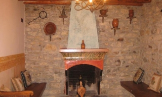 Sala con dos bancos en las paredes y chimenea