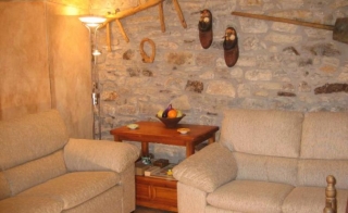 Sala de estar con sillones y pared de piedra