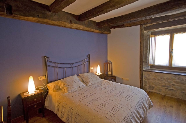 Dormitorio con cama de matrimonio y cabecero de hierro