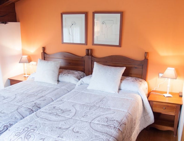 Dormitorio doble con paredes en naranja