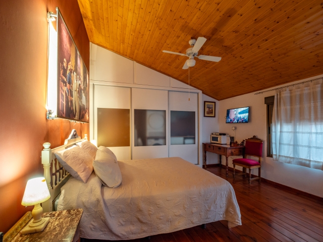Sala de estar con gran television y chimenea de la casa rural