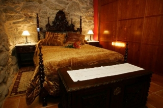Dormitorio señorial de matrimonio con paredes de piedra