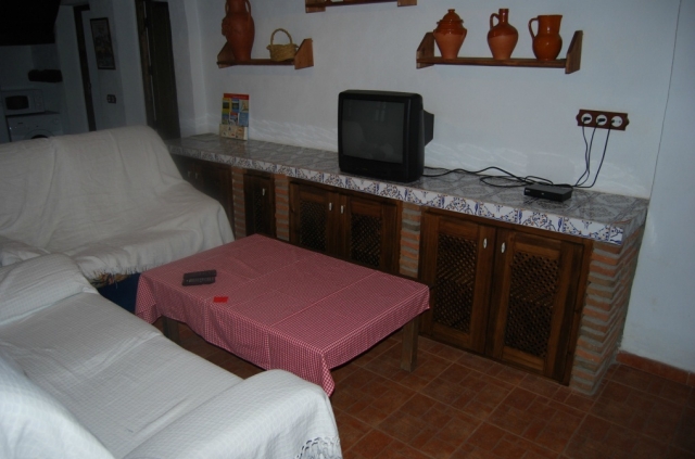 Sala de estar con tele y sillones blancos