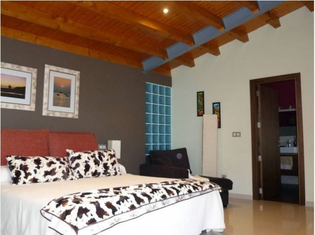 Dormitorio de matrimonio con techo de madera