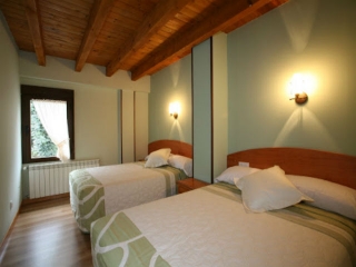 Amplia habitación con 2 camas y ventana de casa rural