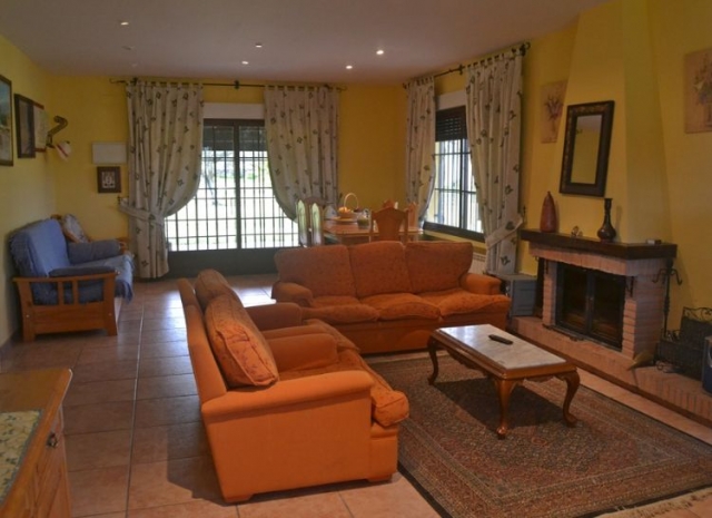 Sala de estar con alfombra y sillones naranjas