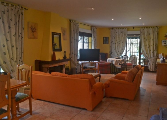 Sala de estar con sillones naranjas y chimenea en el frente