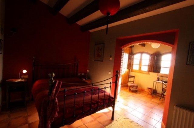 Dormitorio en tonos rojizos con cama de matrimonio