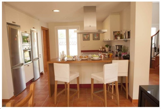 Cocina con barra y taburetes en madera