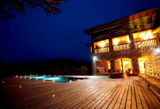 Exterior de la casa con piscina de noche