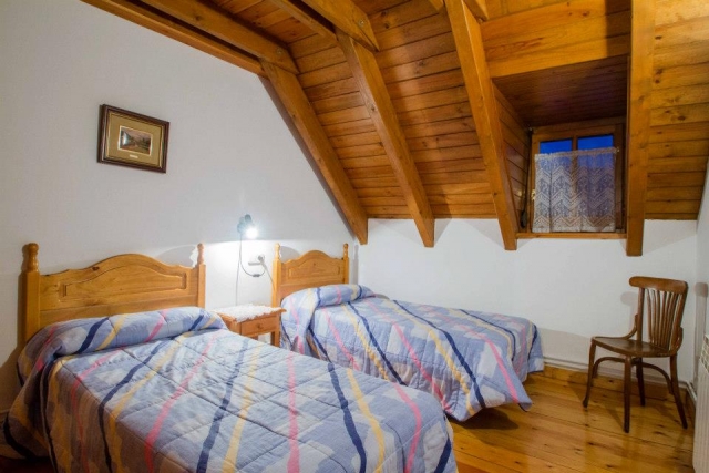 Dormitorio con dos camas abuhardillado