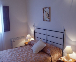 Dormitorio con cama doble y ventana en la casa rural