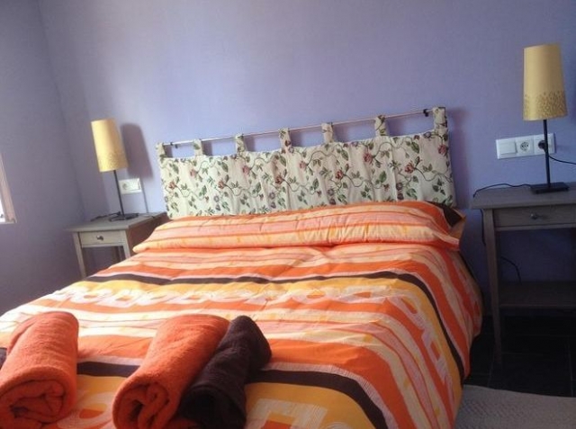 Dormitorio de matrimonio con mesillas y  ropa de cama