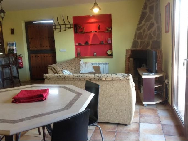 Sala de estar con mesa y chimenea