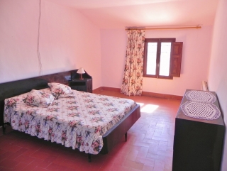Habitación de matrimonio con comoda de madera oscura