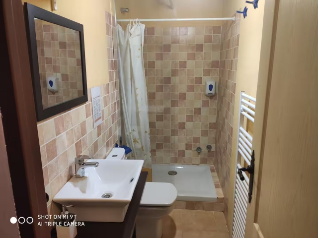 Un aseo con ducha y espejo