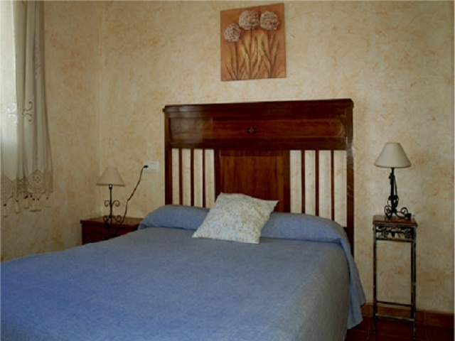 Dormitorio doble con cama de matrimonio con precioso cabecero de madera