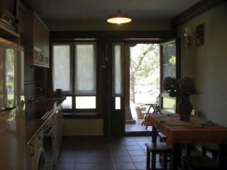 Mesa y cocina y salida al exterior