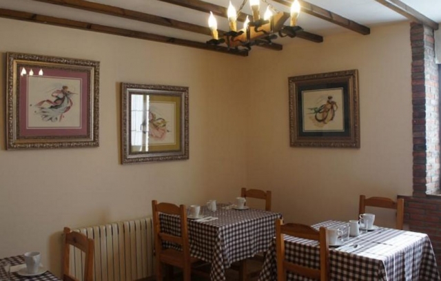 Comedor comunitario con varias mesas junto a las ventanas