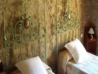 Dormitorio con pared de piedra