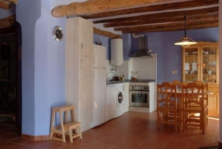 Cocina abierta bien equipada y mesa grande