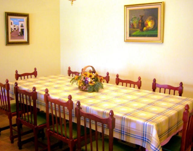 Comedor con mesa de madera y paredes con cuadros