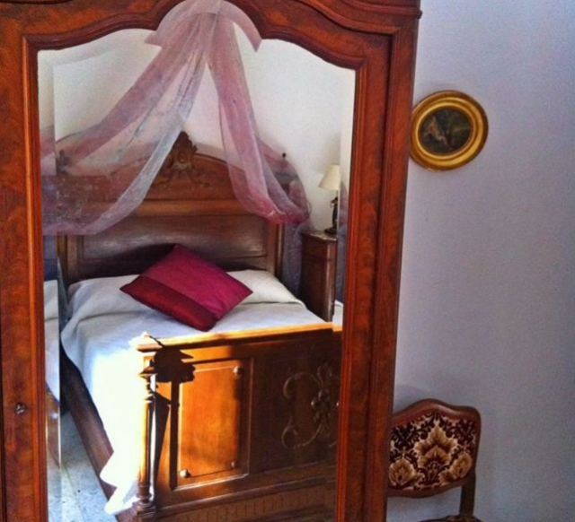 Dormitorio de matrimonio con cabecero de madera tallada