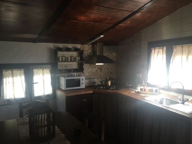 Cocina con mesa de madera y espacio abuhardillo