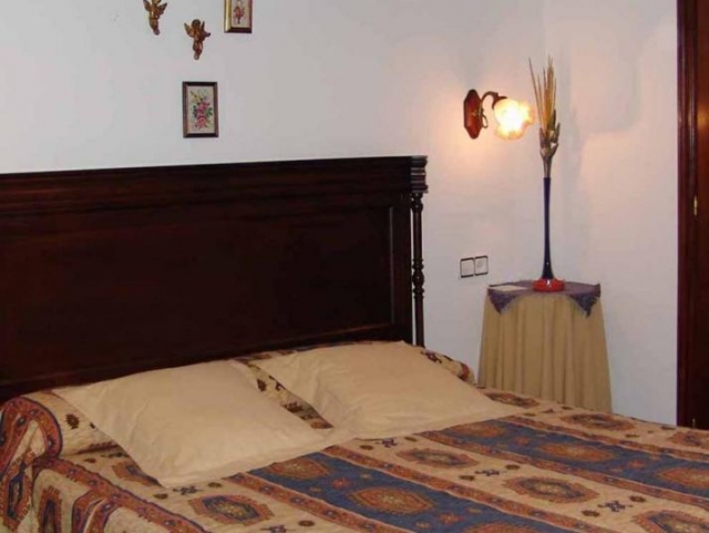 Dormitorio de matrimonio con cojines en tonos crudo