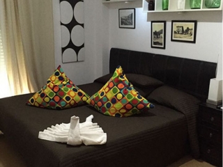 Dormitorio de matrimonio con cojines de colores