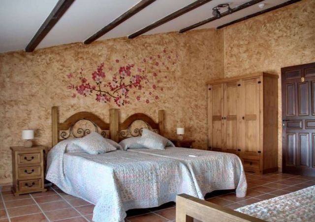 Dormitorio doble con detalles florales en la pared