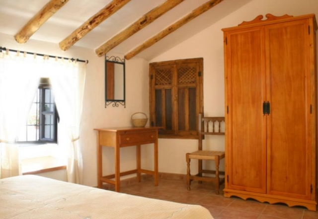 Dormitorio de matrimonio abuhardillado y armario de madera